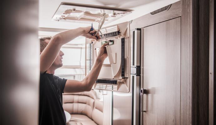 Technician performing RV AC unit repair