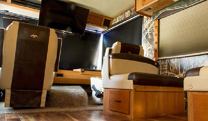 Luxury RV interior with leather seating and entertainment setup