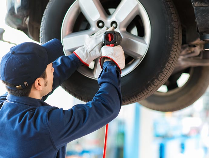 A mechanic is changing a car tire.