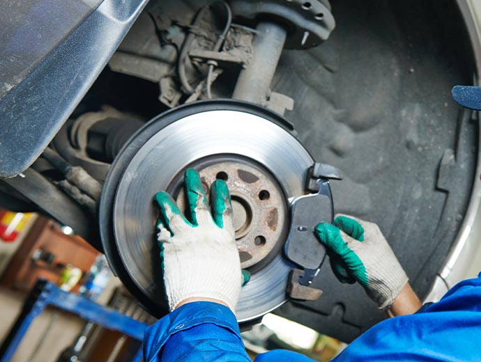 Professional worker inspecting brake problems