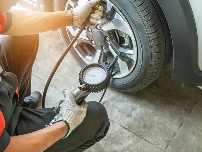 Tire pressure is checked by the technician.