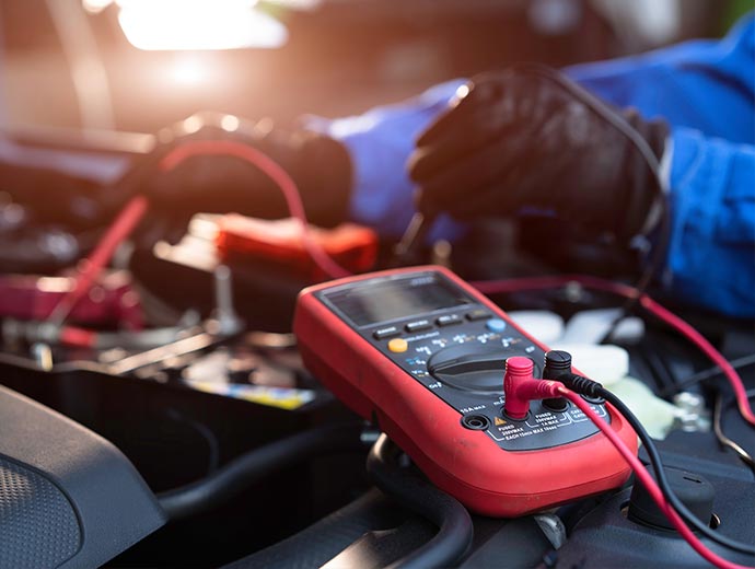 A technician measures the voltage of a battery.